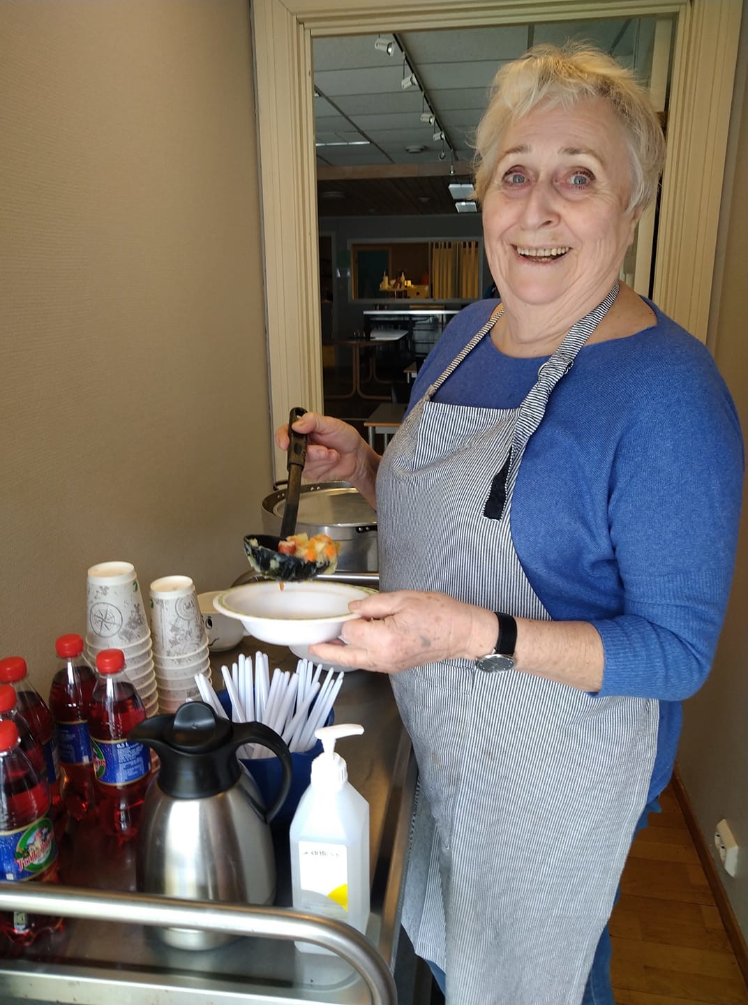 Reidun serverer lapskaus, smørbrød i matpakke, brus og kaffe i en liten kiosk på sammensenteret i Kristiansand